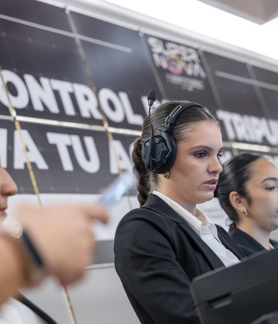 Coordinadora de Tribuna Events supervisando un congreso con intercomunicador.